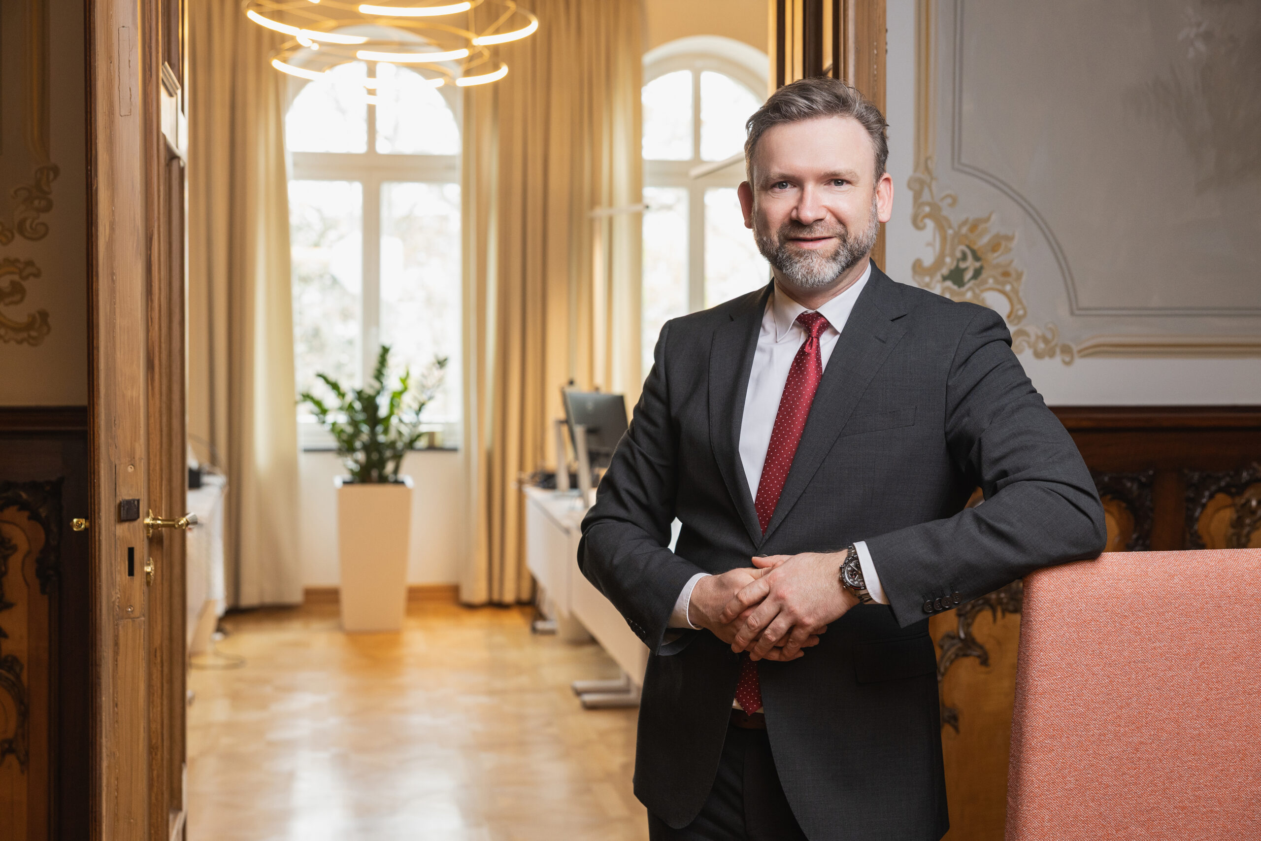 Matthias Wolf steht an ein Sofa gelehnt vor der offenen T&uuml;r des Efficiency Rooms in seinem B&uuml;ro in Bautzen